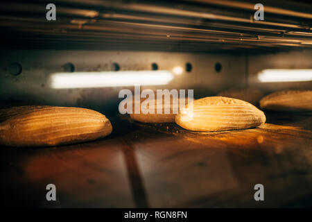 Cottura del pane nel forno in un forno Foto Stock