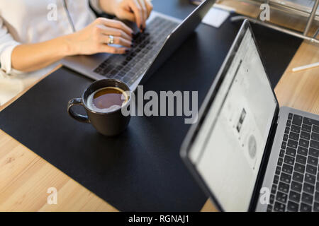 Close-up di donna utilizzando laptop alla scrivania in ufficio Foto Stock