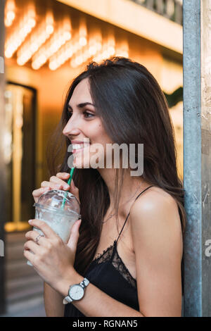 Sorridente giovane donna con i frullati Foto Stock