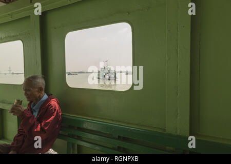 Il vecchio uomo sulla nave traghetto Varcando il fiume Saigon Foto Stock