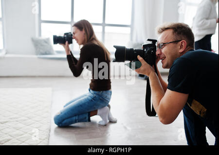 Il team di due fotografi riprese in studio. Fotografo professionista sul lavoro. Foto Stock