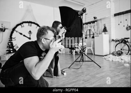 Il team di due fotografi riprese in studio. Fotografo professionista sul lavoro. Foto Stock