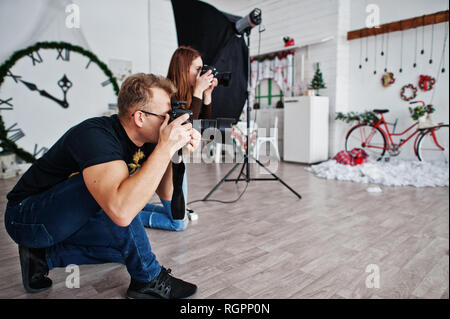 Il team di due fotografi riprese in studio. Fotografo professionista sul lavoro. Foto Stock