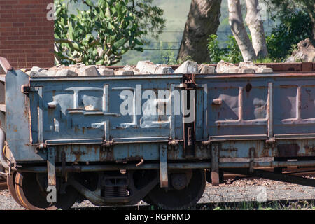 Una vista ravvicinata di un vecchio arrugginito treno aperto carrage con calcestruzzo pillers ferroviarie ancora dentro Foto Stock