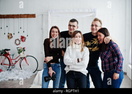 Il gruppo di cinque popoli, amici fotografi e designer sulle riprese in studio dopo la dura giornata di lavoro. Sono felice e ridere. Foto Stock