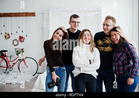 Il gruppo di cinque popoli, amici fotografi e designer sulle riprese in studio dopo la dura giornata di lavoro. Sono felice e ridere. Foto Stock