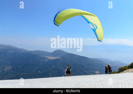 Il giallo di parapendio inizia il suo volo, di fronte alle montagne e il cielo Foto Stock