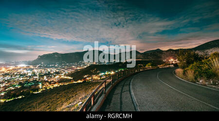 Terracina, Italia. Vista sullo skyline della città Cityscape in sera illuminazione notturna. Notte strada aperta e il bellissimo paesaggio. Panorama, Vista panoramica. Foto Stock