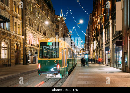 Helsinki, Finlandia. Tram parte dalla fermata su Aleksanterinkatu Street. La notte di Natale la sera di Natale Anno Nuovo festoso via illuminazione. Bella Dec Foto Stock