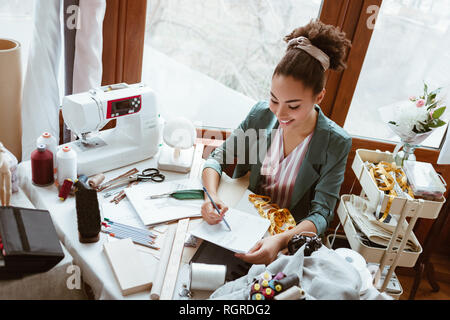 Fare schizzi a non pad. Vista superiore della giovane donna sarto con tampone non è disegno dalla matita in design studio Foto Stock