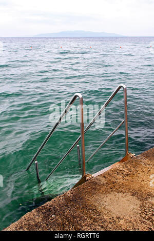 Scala metallica con corrimano per il mare Foto Stock