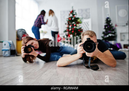 Il team di due fotografi giacciono sul pavimento e riprese in studio. Foto Stock