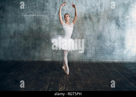 Ballerina femmina. Giovane donna bellissima ballerina, vestito in abiti professionali, pointe scarpe e white tutu. Foto Stock