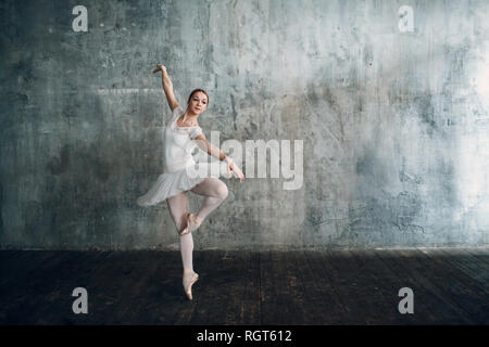 Ballerina femmina. Giovane donna bellissima ballerina, vestito in abiti professionali, pointe scarpe e white tutu. Foto Stock