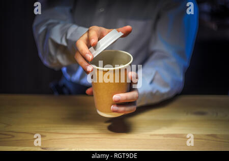 Barista serve caffè al client. Mani bicchiere di carta banco bar Cappuccino il cappuccio di plastica. Caffè il concetto di Business Foto Stock