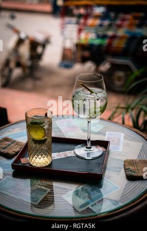 La bevanda alcolica con limone e ghiaccio su un vecchio glas tabella Foto Stock
