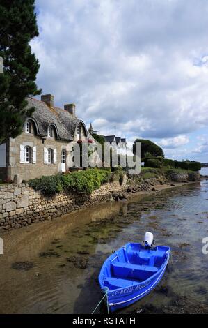 Piccola barca blu nella parte anteriore di un cottage in pietra a Saint Cado Morbihan Bretagna Francia Foto Stock