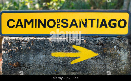 Tradizionale freccia gialla dipinta sul modo. Direzione segno per i pellegrini di Saint James way, Camino de Santiago de Compostela, Spagna Foto Stock