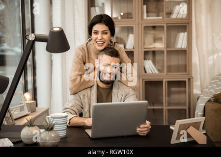 Ridendo attraente donna appoggiata sul retro del suo marito Foto Stock
