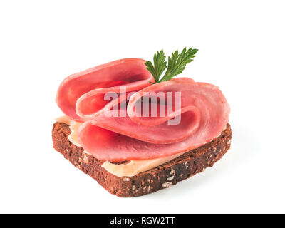 Sandwich freschi con prosciutto e formaggio e foglie di prezzemolo isolato pronto a mangiare. Fetta di pane di segale con prosciutto perfetto isolato su bianco con percorso di clipping. Foto Stock