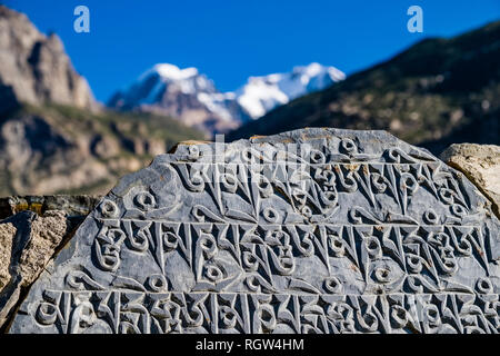 Mani di pietra con le rocce scolpite mantra buddista di Avalokiteshwara, OM MANI PADME HUM, all entrata del villaggio Foto Stock