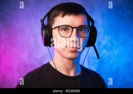 Ritratto di un giovane gioiosa gamer nelle cuffie. Giochi di Computer Concept Foto Stock