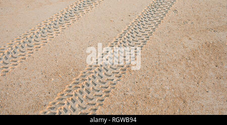 Un'immagine ravvicinata della fascia battistrada del pneumatico segni nella sabbia. Foto Stock