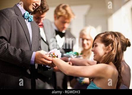 Ragazzi adolescenti dando loro prom date loro corsages. Foto Stock