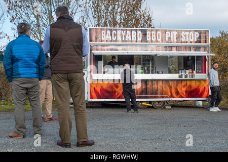 I clienti in attesa del loro cibo gli ordini al barbecue nel cortile Pit Stop strada fast food diner van truck stop, Aberystwyth, Wales UK Foto Stock