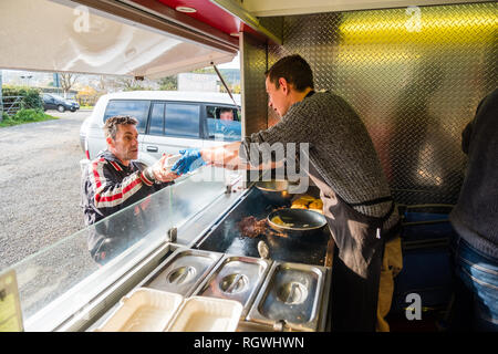 Un uomo che serve un cliente di Backyard barbeque Pit Stop strada fast food diner van truck stop, Aberystwyth, Wales UK Foto Stock