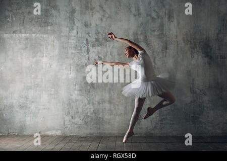 Ballerina femmina. Giovane donna bellissima ballerina, vestito in abiti professionali, pointe scarpe e white tutu. Foto Stock