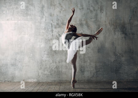 Ballerina femmina. Giovane donna bellissima ballerina, vestito in abiti professionali, pointe scarpe e white tutu. Foto Stock