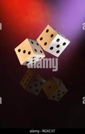 Dado che cade con la riflessione su sfondo scuro Foto Stock