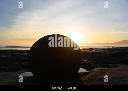 Il misterioso che sono venuti a riposo sul'isola Sud della Nuova Zelanda East coast beach di Moeraki sono loro più bei a sunrise. Foto Stock