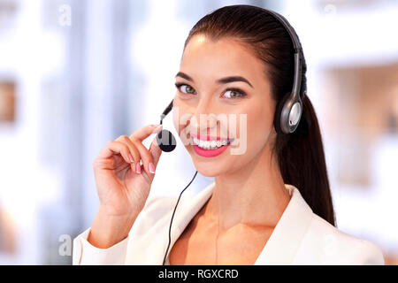 Closeup shot di giovani piuttosto call center lavoratore con cuffia Foto Stock