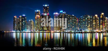 Panorama di Busan Marina city grattacieli accesa nella notte con la riflessione in acqua, Corea del Sud Foto Stock