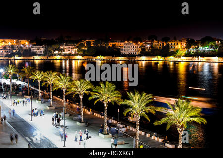 I turisti e i locali godono di una tarda notte sul lungomare Promenade presso il porto di Brindisi in Puglia, regione dell'Italia meridionale. Foto Stock