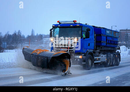 Salo, Finlandia - 26 gennaio 2019: Il camion blu Scania dotato di spazzaneve sgombrerà una strada nevosa nell'area suburbana in un pomeriggio d'inverno. Foto Stock