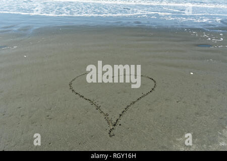 Un semplice disegnato a mano cuore d'amore nella sabbia Foto Stock
