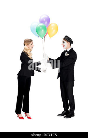 Allegro clown dando palloncini alla donna in tuta isolato su bianco Foto Stock