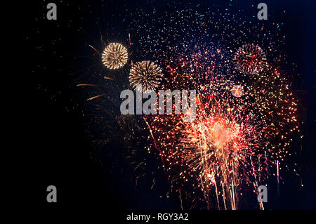 Rosso, arancione, blu e giallo i fuochi d'artificio su sfondo nero con spazio per la copia. Foto Stock