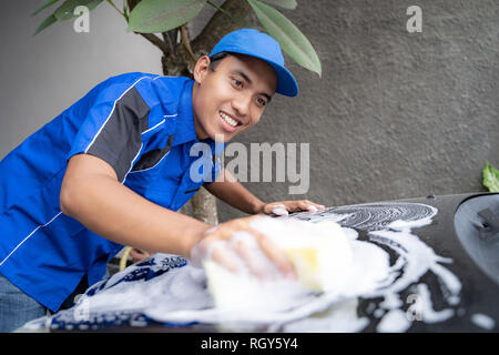 Auto Service personale in uniforme blu pulizia auto Foto Stock