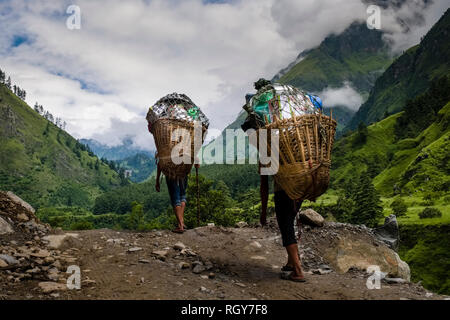 Due sono i facchini che trasportano carichi pesanti in un cestello fino la Kali Gandaki valley Foto Stock
