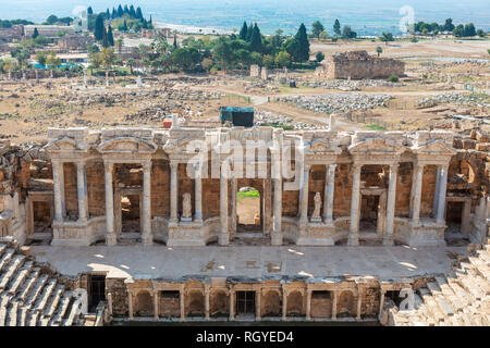 Teatro all'antica città di Hierapolis con la moderna città di Pamukkale in Turchia interna della regione del Mar Egeo. Foto Stock