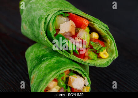 Burrito di carne bovina, cibo messicano. Burrito si avvolge con manzo e verdure su sfondo nero. Foto Stock