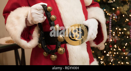 Un close up Foto di Santa's ventre tenendo la sua cinghia e sleigh bells. Foto Stock