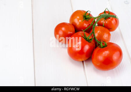 Il ramo di pomodori rossi su lavagne bianche. Foto Studio Foto Stock