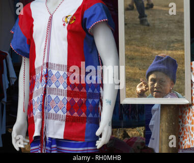 Thay Bay Hla, Myanmar. 31 gennaio, 2019. Una donna Karen si vede riflessa su uno specchio accanto a un Karen custom al suo negozio durante la cerimonia.il settantesimo anniversario della Rivoluzione Karen giorno alla Baia di Thay Hla in stato di Karen lungo il confine Thai-Myanmar. Credito: Chaiwat Subprasom SOPA/images/ZUMA filo/Alamy Live News Foto Stock