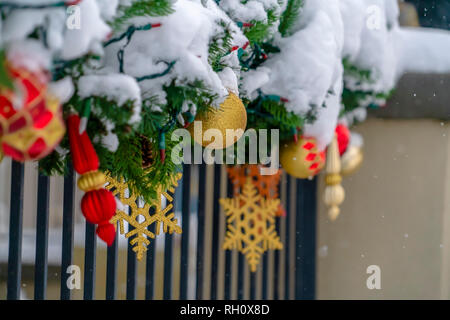 Close up di ringhiera con una ghirlanda ricoperta di neve Foto Stock