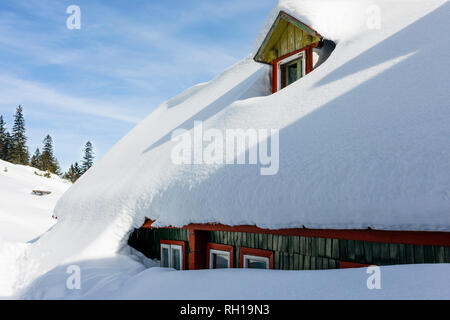 Cottage di legno tetto coperto di neve nelle montagne dei Carpazi Foto Stock